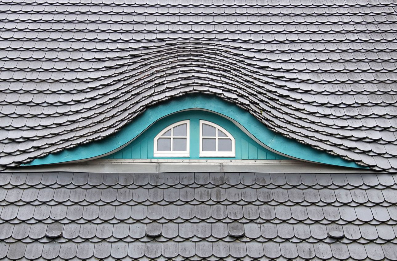 Schieferdach mit einem rundem Fenster